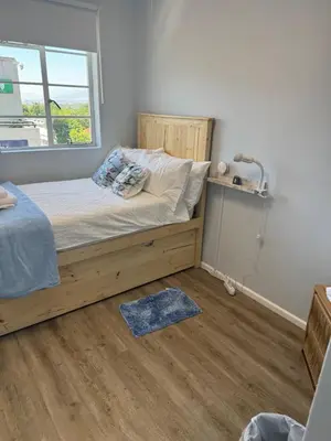 a bedroom with a bed and a window at Windpomp Self Catering in Paarl