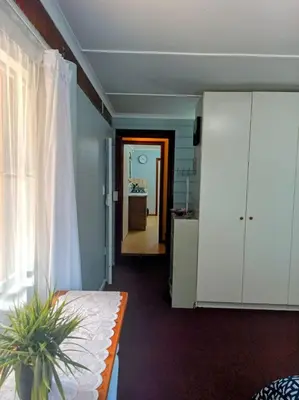 a living room with a table and a kitchen at LAAT Slaap Self-Catering Accommodation in Kleinmond