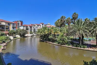 a body of water with palm trees and buildings at 107 St Tropez Eyrie Holiday Apartments in Cape Town