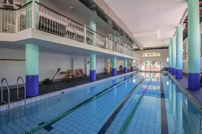 a large indoor swimming pool with blue columns at 107 St Tropez Eyrie Holiday Apartments in Cape Town