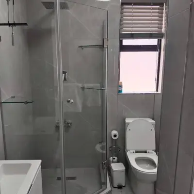 a bathroom with a shower and a toilet and a sink at 107 St Tropez Eyrie Holiday Apartments in Cape Town