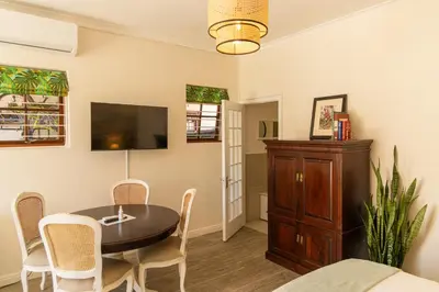 a dining room with a table and chairs and a tv at Mitre's Edge Simonsberg Studio in Klapmuts