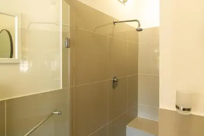 a bathroom with a shower with a glass door at Mitre's Edge Simonsberg Studio in Klapmuts