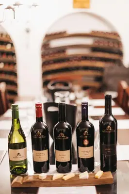 three bottles of wine sitting on a cutting board at Mitre's Edge Simonsberg Studio in Klapmuts