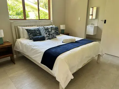 a bedroom with a large bed with pillows at Lily's Lodge in Somerset West