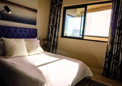 a bedroom with a bed and a window at Knightsbridge Luxury Escape in Cape Town