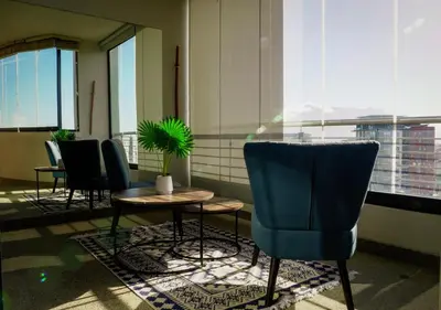 a room with chairs and a table and a potted plant at Knightsbridge Luxury Escape in Cape Town