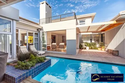a house with a swimming pool in front of a house at Sunsets Jasmine Villa in Cape Town