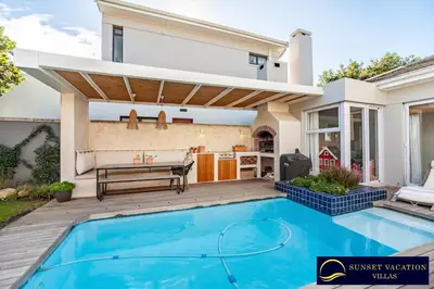 a swimming pool in a backyard with a house at Sunsets Jasmine Villa in Cape Town