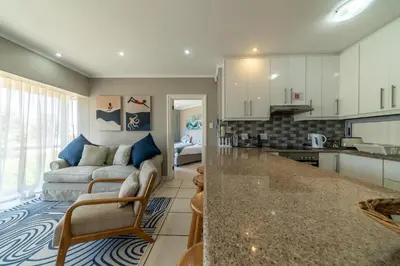 a living room with a couch and a kitchen at 4 Serene Palms in Cape Town