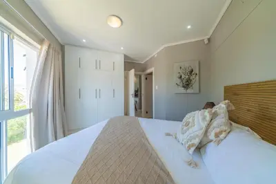 a bedroom with a large bed and a window at 4 Serene Palms in Cape Town