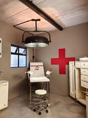 a room with a chair and a red cross on the wall at Tether and Tease, The Citadel in Cape Town