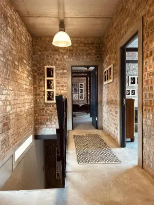 a room with a brick wall and a hallway at Tether and Tease, The Citadel in Cape Town