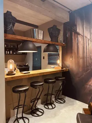 a kitchen with three bar stools at a counter at Tether and Tease, The Citadel in Cape Town