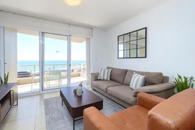 a living room with a couch and a table at Wake Up to the Waves - Portico in Cape Town