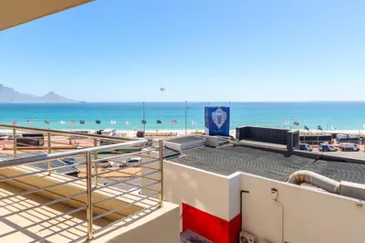 a view of the beach from the balcony of a building at Wake Up to the Waves - Portico in Cape Town