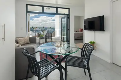 a living room with a glass table and chairs at Perlemoen Apartments in Hermanus