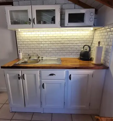 a kitchen counter with a sink and a microwave at The Sculpture Yard in Gordonʼs Bay