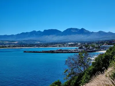 a view of a body of water with mountains in the background at The Sculpture Yard in Gordonʼs Bay