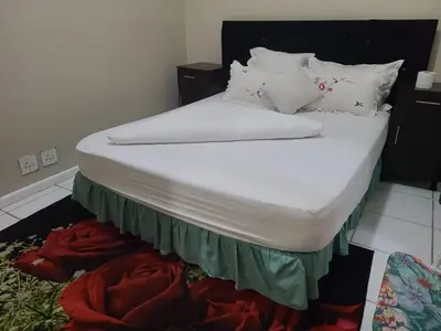 a bed with white sheets and pillows in a room at Skyway Sleep and go in Cape Town