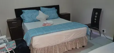 a bedroom with a bed with blue pillows at Skyway Sleep and go in Cape Town