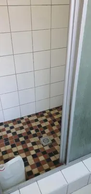 a bathroom with a shower with a checkered floor at Skyway Sleep and go in Cape Town