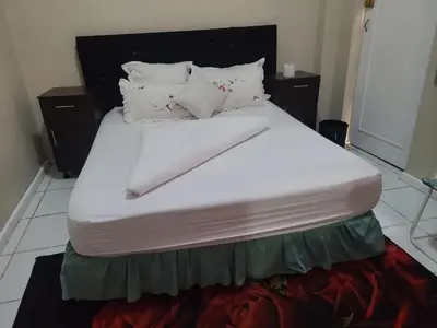 a large bed with white sheets and pillows at Skyway Sleep and go in Cape Town