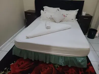 a bed with white sheets and pillows on it at Skyway Sleep and go in Cape Town
