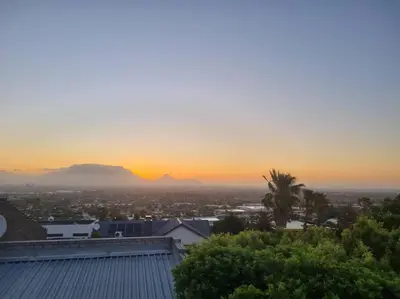 a sunset over a city with mountains in the background at Grace Space in Plattekloof in Cape Town