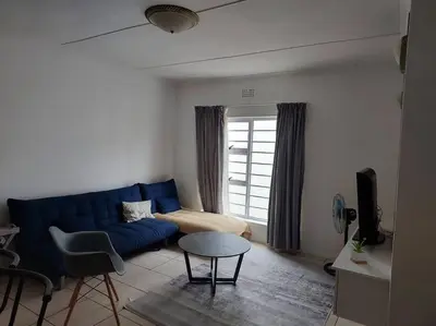 a living room with a blue couch and a window at Azzure Apartments 3 sleeper Strand in Strand