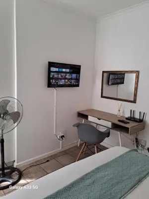 a bedroom with a desk and a chair and a mirror at Azzure Apartments 4 sleeper Strand in Strand