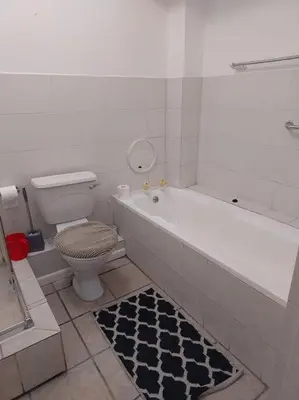 a bathroom with a tub and a toilet and a rug at Azzure Apartments 4 sleeper Strand in Strand