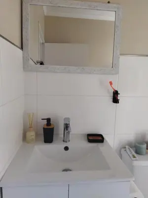 a white sink in a bathroom with a mirror at 21 Pin Oak Guest House in Cape Town