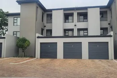 a building with two garage doors in front of it at Cozy Apartment in Brackenfell, Cape Town, ZA in Brackenfell