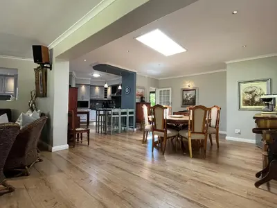 a dining room and living room with a table and chairs at 7Pillars Villa Grenache in Durbanville