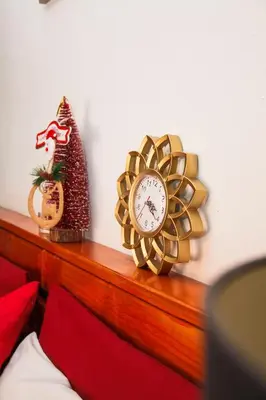 a gold clock on a shelf with a christmas ornament at Luxurious Flatlet in the heart of Mowbray in Cape Town