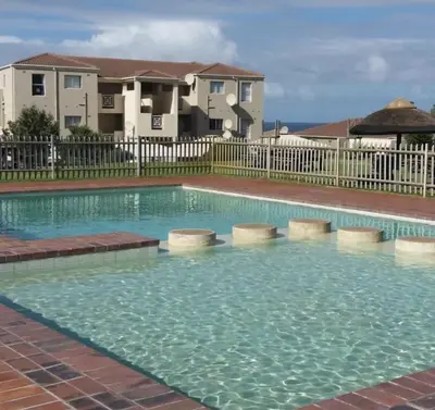 a large swimming pool in front of a building at Hermanus Beach Club 104 in Hermanus