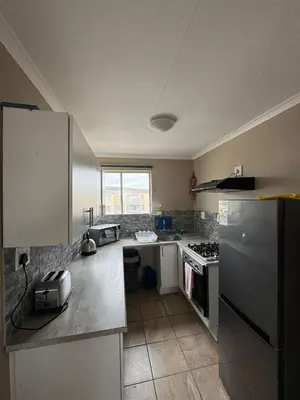 a kitchen with a sink and a stove top oven at Hermanus Beach Club 104 in Hermanus