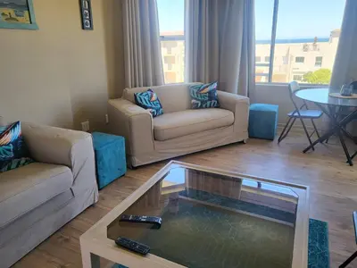 a living room with two couches and a coffee table at Hermanus Beach Club 104 in Hermanus