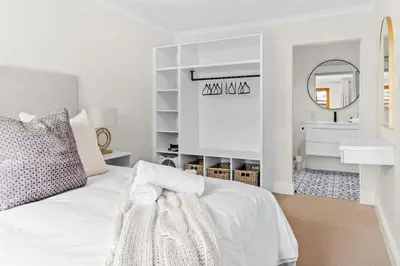 a white bedroom with a white bed and a sink at 2D on Nansen in Cape Town