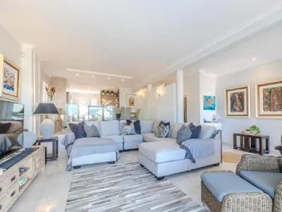a living room with a couch and a tv at Hermanus - Heart of the Sea in Hermanus
