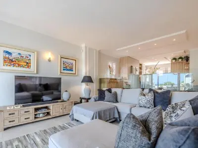 a living room with a couch and a tv at Hermanus - Heart of the Sea in Hermanus