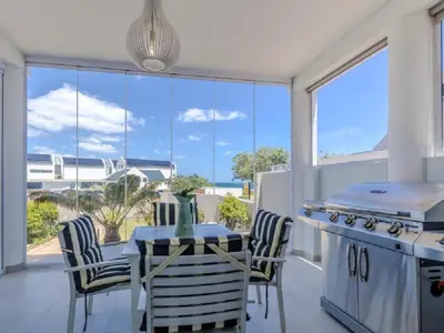 a kitchen with a table and chairs with a view of the ocean at Hermanus - Heart of the Sea in Hermanus