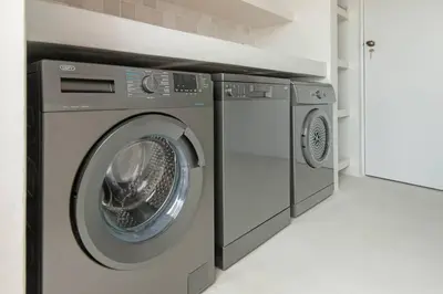 a washing machine and a dryer in a laundry room at Heartwood Cottage in Hermanus