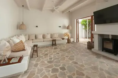 a living room with a white couch and a fireplace at Heartwood Cottage in Hermanus