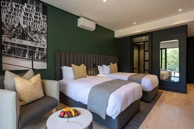 a hotel room with two beds and a couch at Franschhoek Hotel in Franschhoek