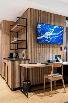 a kitchen with a wooden wall with a table and a tv at Franschhoek Hotel in Franschhoek