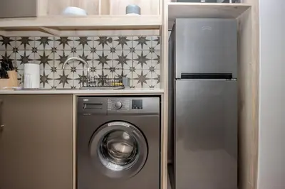a kitchen with a washing machine and a refrigerator at 23 On The Den Studio Apartment in Stellenbosch