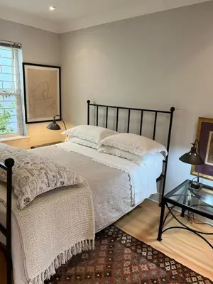 a bedroom with a bed and a glass table at Sandpipers in Hermanus
