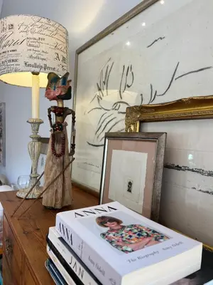 a table with a book and a lamp and a picture at Sandpipers in Hermanus